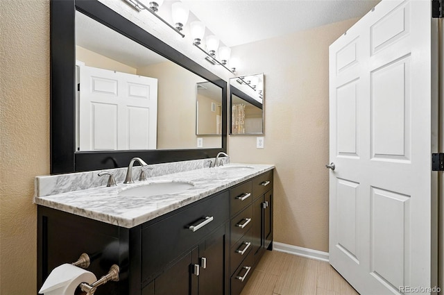 9963 E Carolina Cir Unit 104, Aurora, CO 80247 - full bath with double vanity, baseboards, and a textured wall