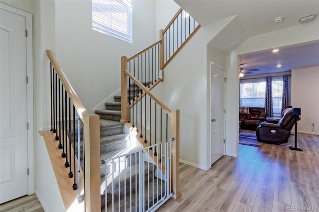 stairway with ceiling fan and hardwood / wood-style floors