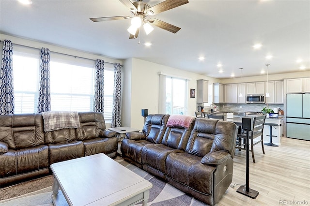 living room featuring ceiling fan and light hardwood / wood-style floors