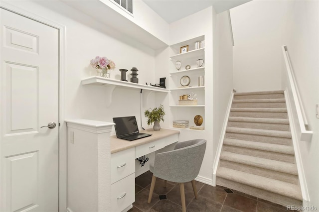 office featuring built in desk, visible vents, dark tile patterned floors, and baseboards