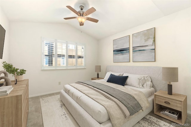 bedroom featuring light colored carpet, vaulted ceiling, baseboards, and ceiling fan