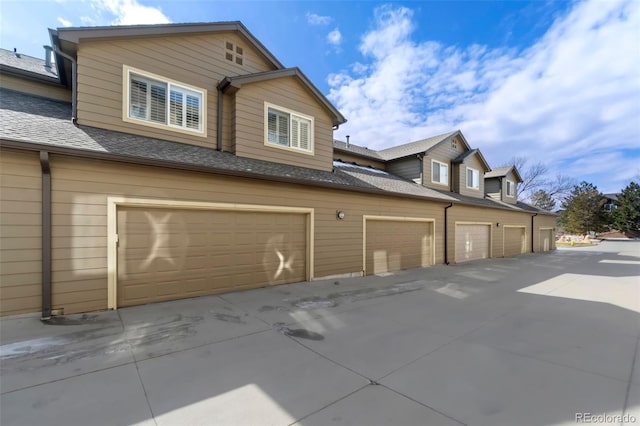 exterior space featuring a garage and a shingled roof