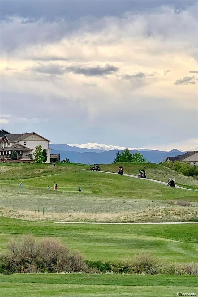 view of property's community featuring a lawn and a mountain view