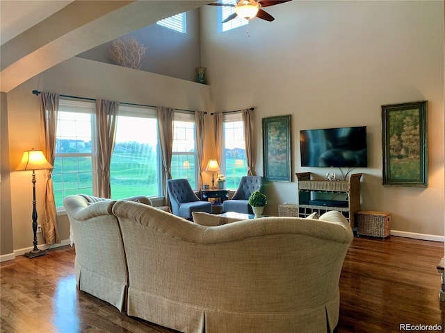 living room featuring ceiling fan, dark hardwood / wood-style flooring, and a towering ceiling