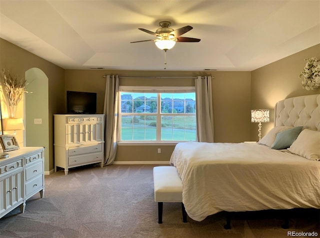 bedroom featuring a tray ceiling, ceiling fan, and light colored carpet