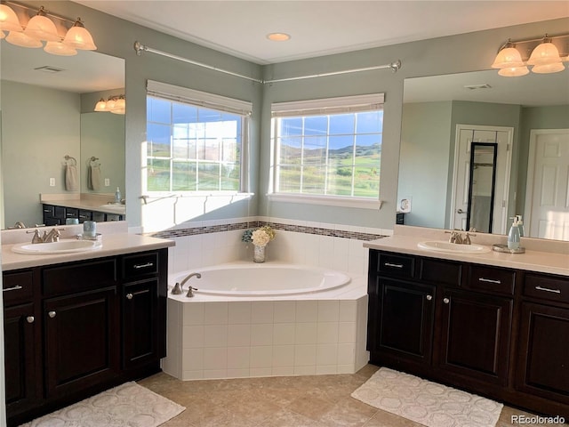 bathroom with vanity, tile patterned flooring, and a relaxing tiled tub