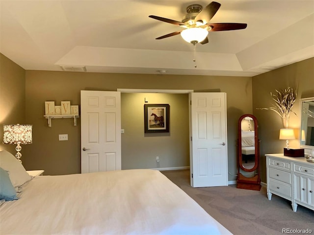 bedroom featuring carpet flooring, ceiling fan, and a tray ceiling