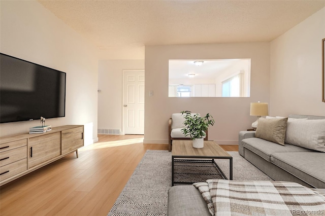 living room featuring a textured ceiling and light hardwood / wood-style floors