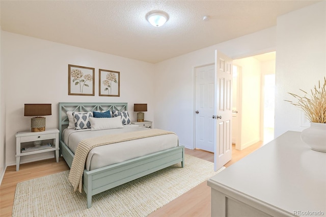 bedroom featuring light hardwood / wood-style flooring and a textured ceiling