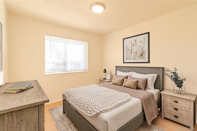 bedroom featuring a textured ceiling and light wood-type flooring