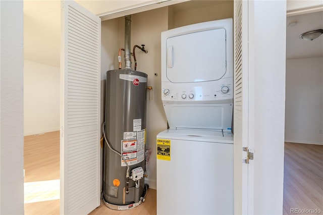 laundry room with water heater, stacked washer and clothes dryer, and light hardwood / wood-style flooring