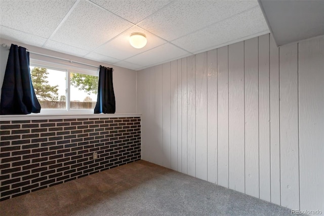 2493 S Kalispell Cir, Aurora, CO 80013 - spare room featuring carpet floors, wooden walls, and a drop ceiling