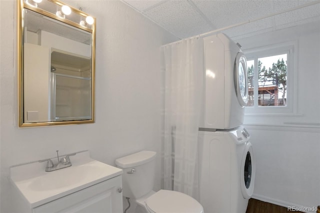 2493 S Kalispell Cir, Aurora, CO 80013 - bathroom with stacked washer and clothes dryer, a shower with shower curtain, vanity, and a drop ceiling