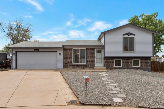 2493 S Kalispell Cir, Aurora, CO 80013 - tri-level home with a garage, driveway, brick siding, entry steps, and a shingled roof