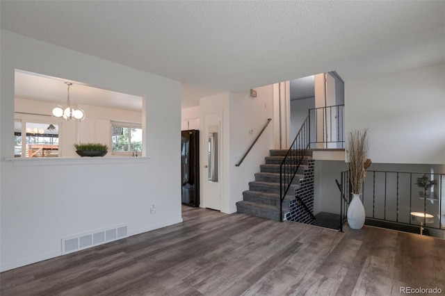 2493 S Kalispell Cir, Aurora, CO 80013 - living room with wood finished floors, a chandelier, stairway, and a textured ceiling