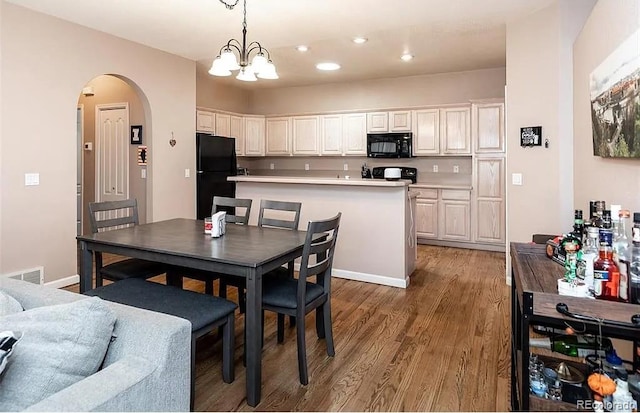 dining room with arched walkways, recessed lighting, wood finished floors, visible vents, and an inviting chandelier