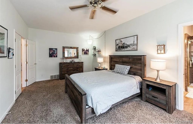 carpeted bedroom featuring ensuite bath, baseboards, visible vents, and ceiling fan