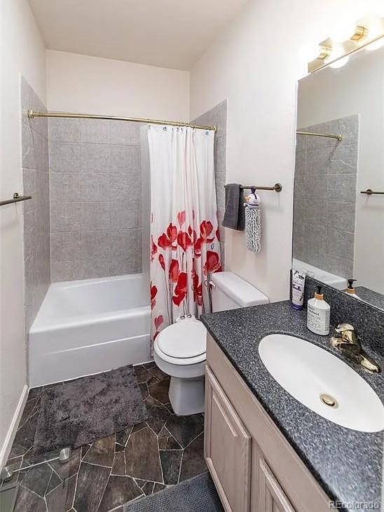 bathroom with vanity, toilet, and shower / bathtub combination with curtain