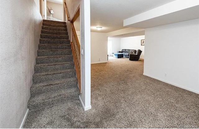 stairway with baseboards and carpet flooring