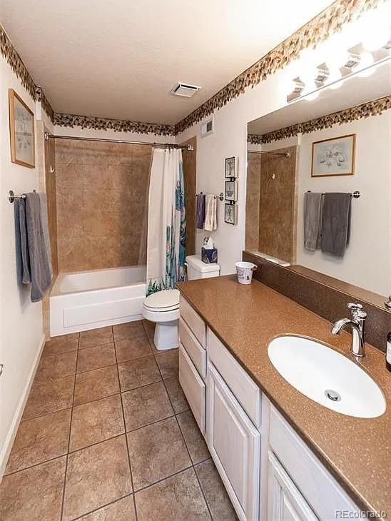 full bath featuring tile patterned flooring, toilet, visible vents, vanity, and shower / bath combo