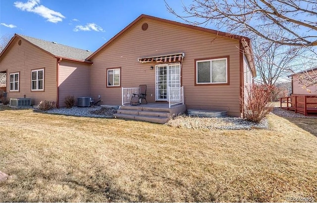 back of house featuring a lawn and central AC unit