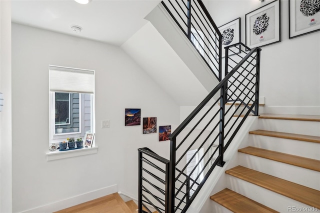 1299 Newton St, Denver, CO 80204 - staircase featuring baseboards, wood finished floors, and lofted ceiling