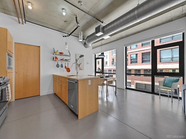 kitchen with stainless steel appliances, a sink, a peninsula, modern cabinets, and concrete flooring