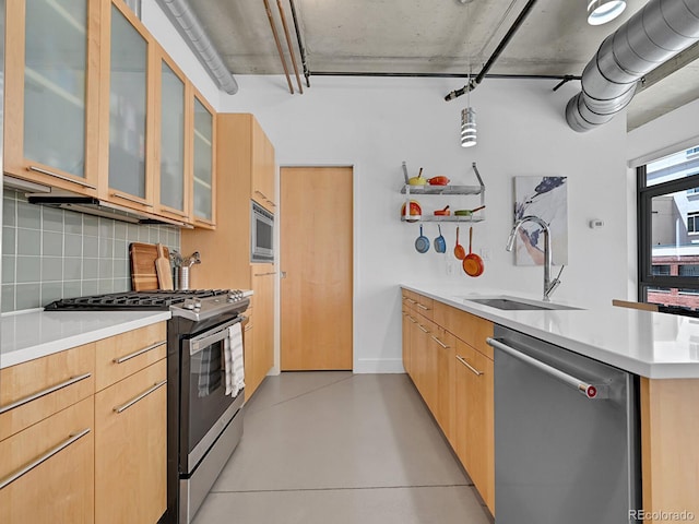 kitchen with appliances with stainless steel finishes, a sink, backsplash, modern cabinets, and a peninsula