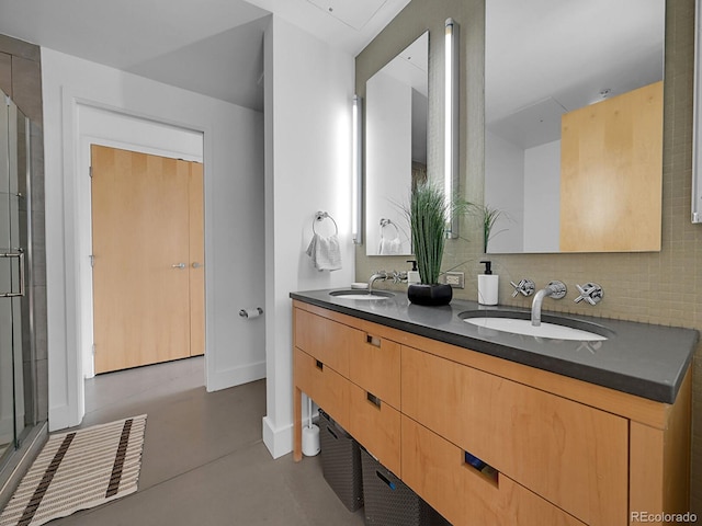 bathroom with finished concrete flooring, a stall shower, baseboards, and double vanity
