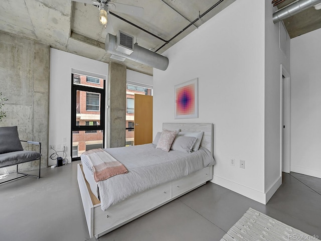 bedroom with finished concrete floors and baseboards