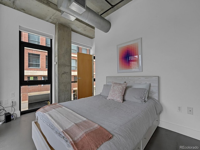 bedroom with concrete floors and baseboards