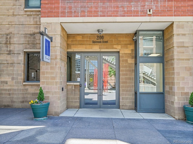 view of exterior entry with french doors and brick siding