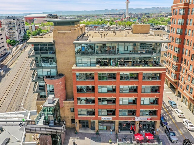 view of building exterior featuring a mountain view and a view of city