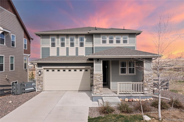 prairie-style home with a porch, an attached garage, concrete driveway, and stone siding