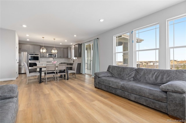 living room featuring a healthy amount of sunlight, recessed lighting, and light wood-style flooring