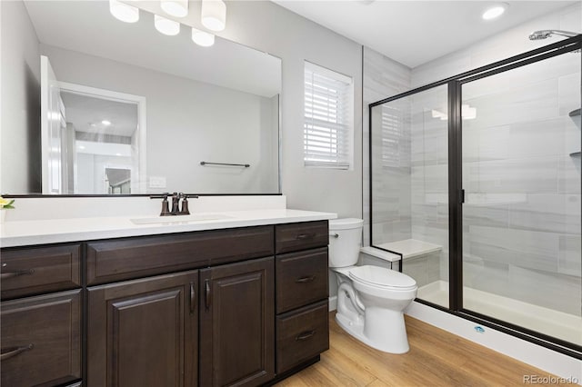 full bath with vanity, wood finished floors, toilet, and a shower stall