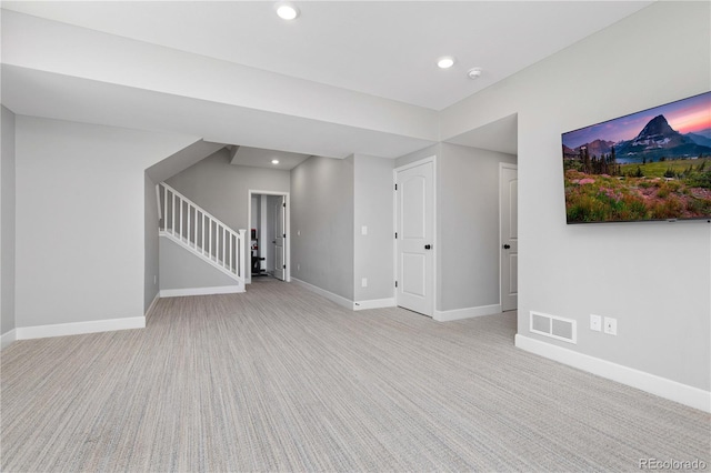 unfurnished living room with visible vents, stairs, baseboards, and light colored carpet