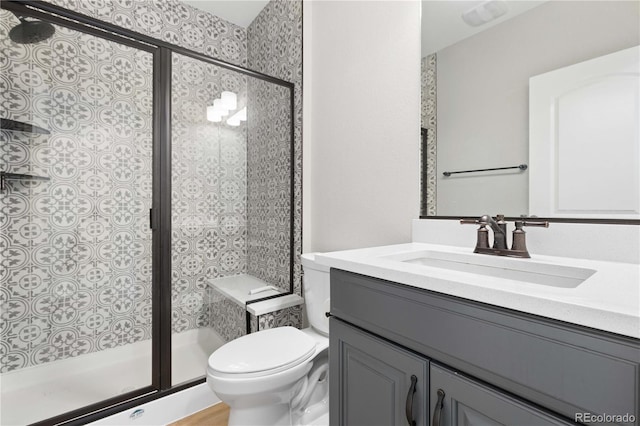 full bath with vanity, a shower stall, and toilet