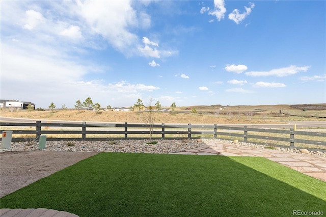 view of yard with a rural view and fence