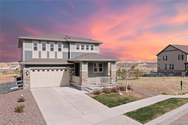prairie-style house with a porch, a garage, fence, and concrete driveway