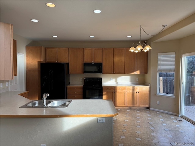 kitchen with hanging light fixtures, black appliances, a notable chandelier, and sink