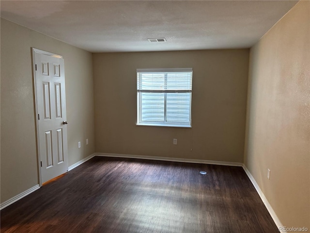 empty room with dark hardwood / wood-style flooring