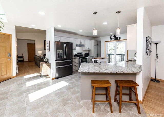 630 Rock Creek Mesa Rd, Colorado Springs, CO 80926 - kitchen featuring a peninsula, range with two ovens, a sink, under cabinet range hood, and black refrigerator with ice dispenser