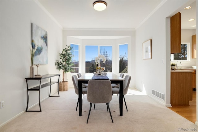 dining space with recessed lighting, light colored carpet, visible vents, baseboards, and crown molding