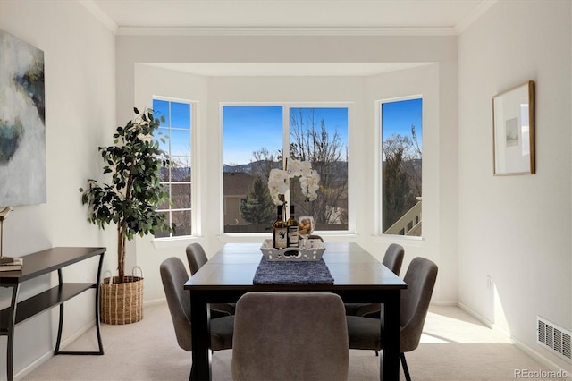 carpeted dining space featuring ornamental molding, visible vents, and baseboards