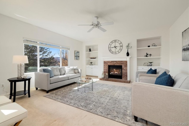 carpeted living room featuring built in features, a fireplace, and a ceiling fan