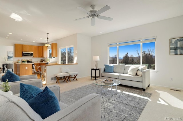 living area with light colored carpet, visible vents, baseboards, and recessed lighting