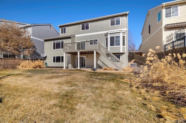 back of property featuring stairs, fence, a deck, and a yard