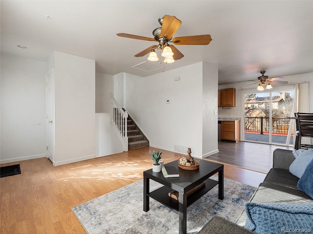 living room with light wood-type flooring and ceiling fan