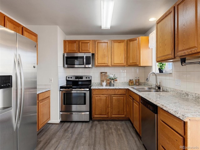 kitchen with appliances with stainless steel finishes, tasteful backsplash, light stone countertops, and sink